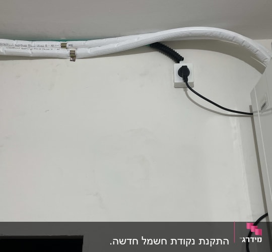 כבל חשמל מחובר לשקע בקיר